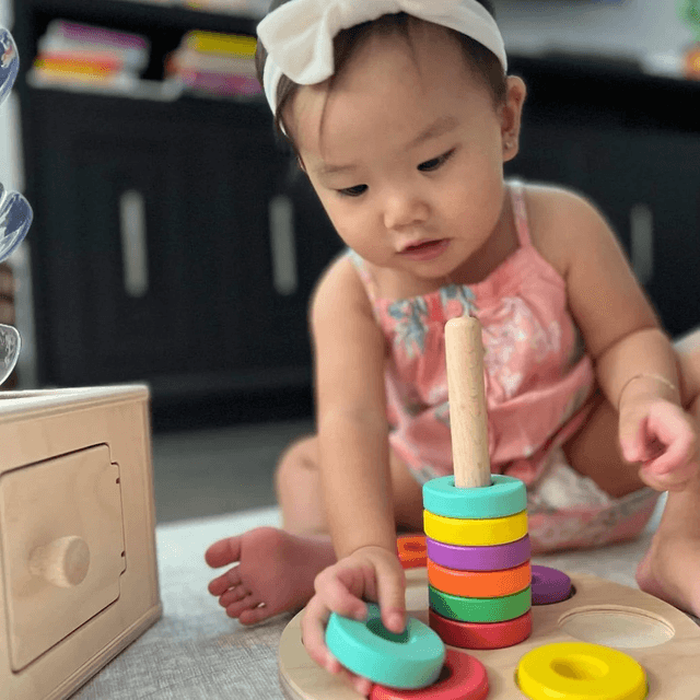 Child sitting with playthings from The Babbler Play Kit