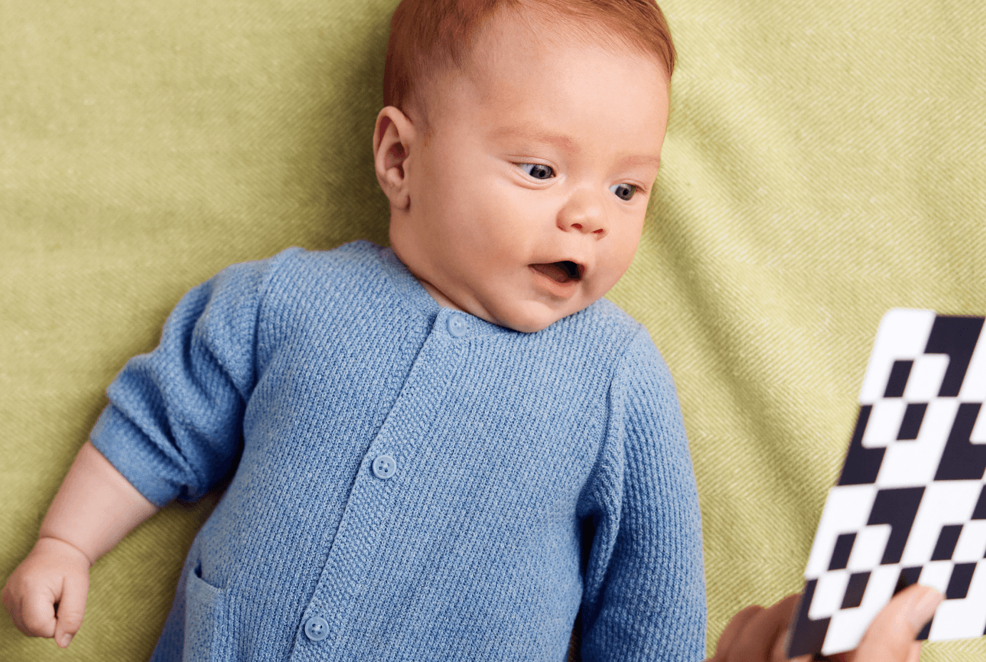 Happy baby looking at Black and White cards from Lovevery